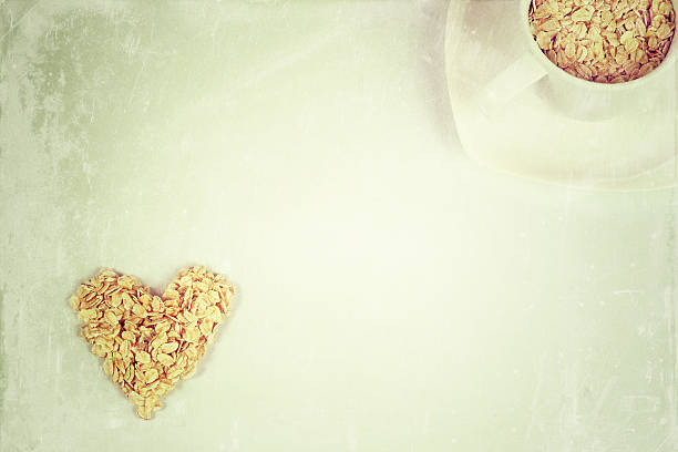 flocons d'avoine dans une forme de cœur et tasse - oatmeal oat heart shape rolled oats photos et images de collection