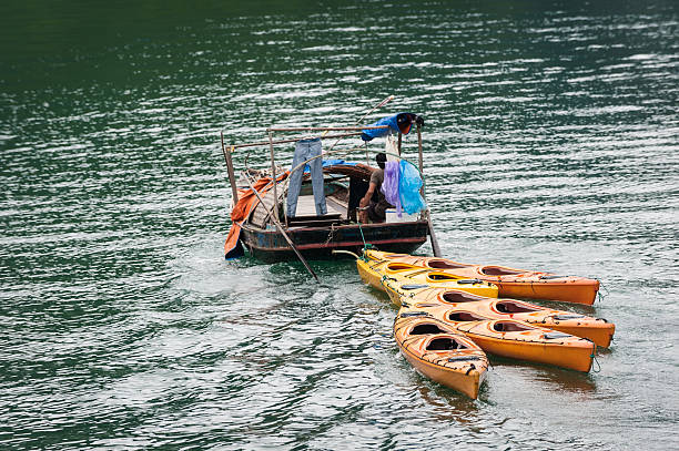 istock Small boat towing colorful kayaks 528465865