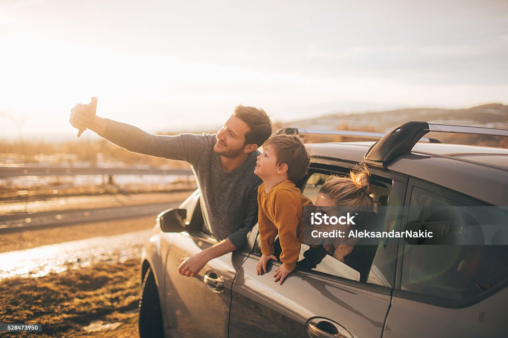 Making memories Photo of cute little family posing for the selfie in the nature, during their excursion with family car Car Stock Photo