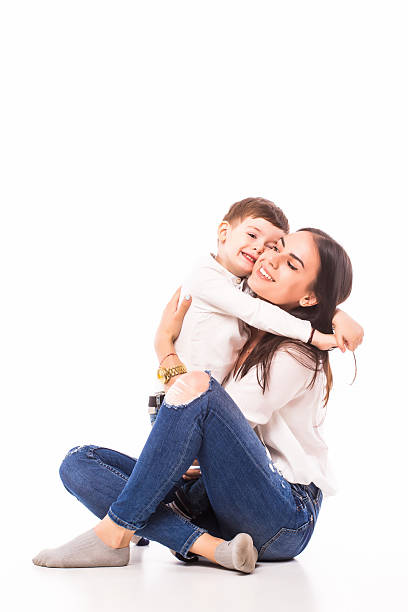 Happy young mother and her son posing together. Isolated over white.
