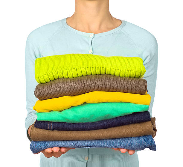 istock Woman hold clothes pile against 528475942