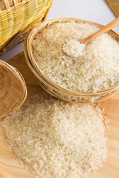 istock Raw and uncooked rice in wooden spoon. 528476262