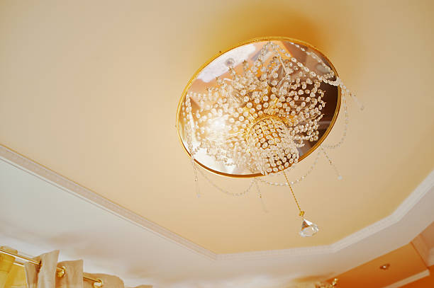 istock Golden and mirror chandelier with point light on orange ceiling 528477354