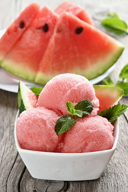 Watermelon sorbet in bowl on wooden background stock photo