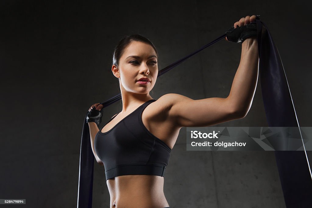 woman with expander exercising in gym fitness, sport, training, people and lifestyle concept - woman doing exercises with expander or resistance band in gym Rubber Band Stock Photo