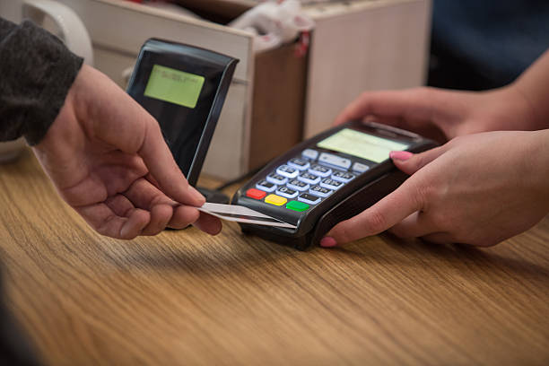 istock Man at counter paying with credit card 528482352