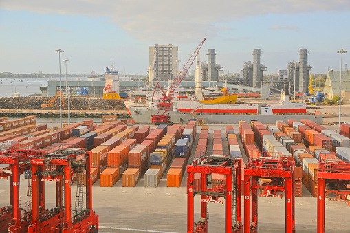 Palm Beach, USA-April 12, 2016: Container port showing the loading machinery, loading crane,  containers and container ship.