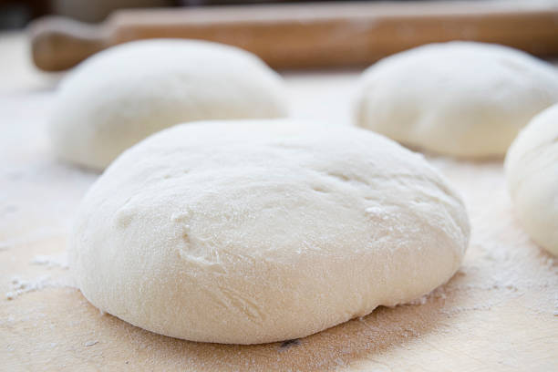 istock ball of pizza dough with flour on a table 528483838