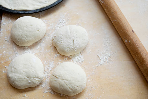 istock balls of pizza dough with flour on a table 528484080