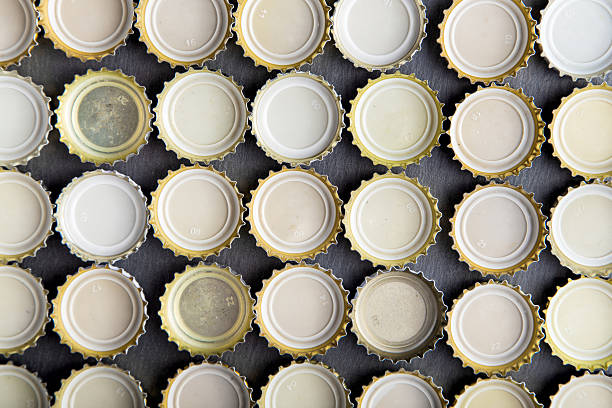 upturned caps of beer lined up in rows, top view