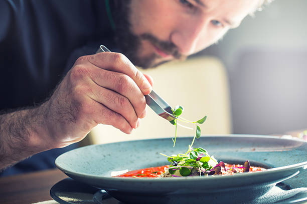 el chef en una cocina a la vista del restaurante de cocina, sólo manos. preparar la sopa de tomate - final touch fotografías e imágenes de stock