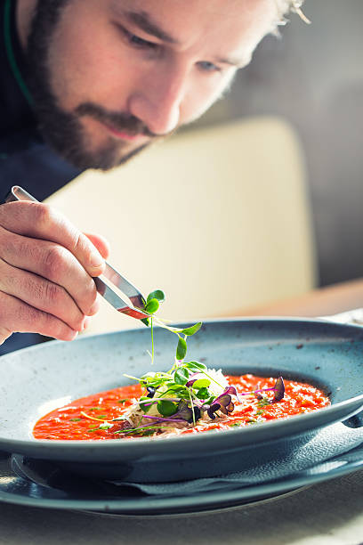 istock Chef in hotel restaurant kitchen cooking, only hands.Preparing tomato soup 528486440