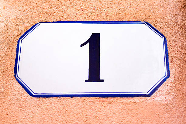 istock Number 1 Street Address Tile on Orange-Pink Stucco Wall (Close-Up) 528487712