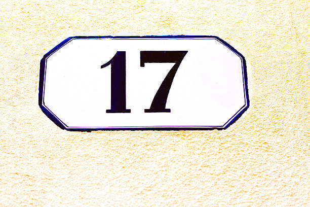istock Number 17 Street Address Tile On Yellow Stucco Wall (Close-Up) 528487864