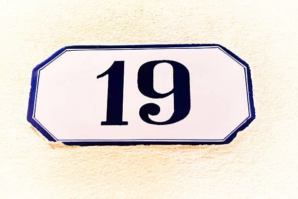istock Number 19 Street Address Tile On Yellow Stucco Wall (Close-Up) 528487938