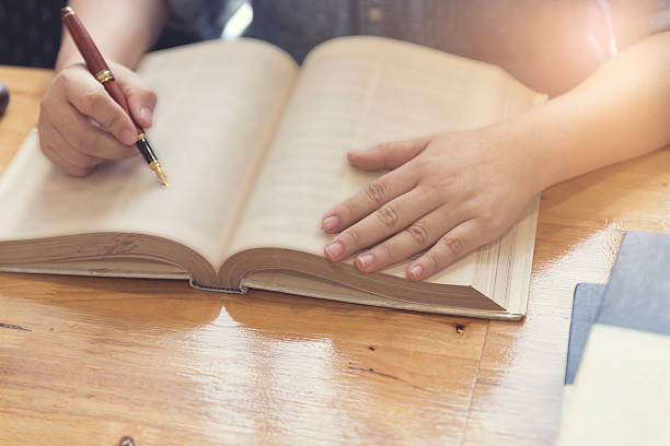 istock woman's hand reading book on wooden table 528493608