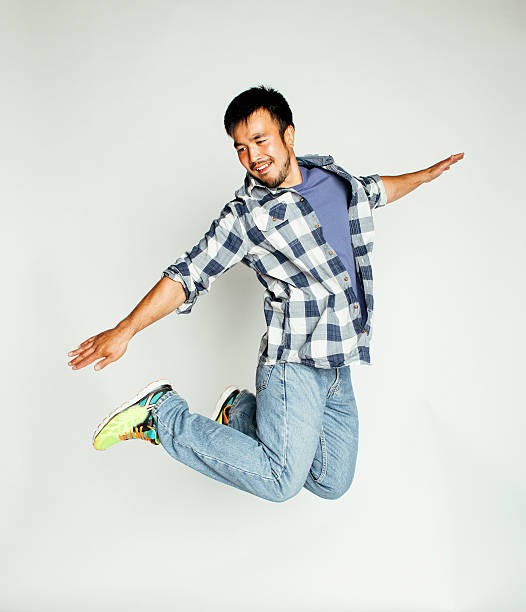 istock young pretty asian man jumping cheerful against white background, lifestyle 528493786