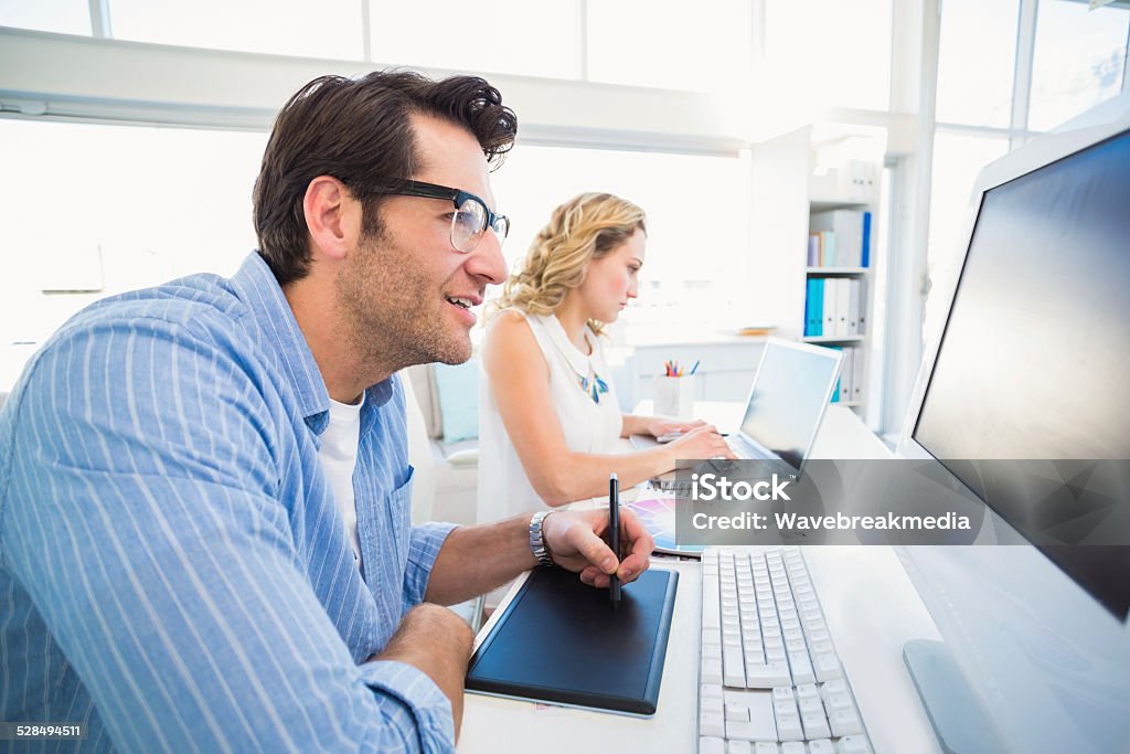 Graphic designer using a graphics tablet Graphic designer using a graphics tablet in his office  20-24 Years Stock Photo