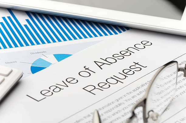 Leave of absence request form on a desk with paperwork Leave of absence request form on a desk with paperwork and digital tablet. Close up. disappear stock pictures, royalty-free photos & images