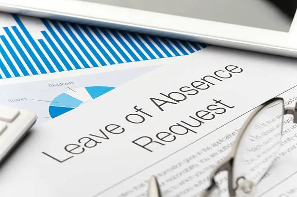 Photo of Leave of absence request form on a desk with paperwork