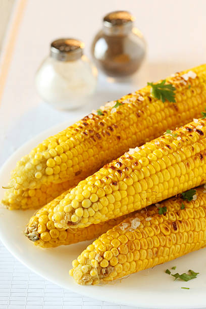 istock Fresh tasty grilled corn on white plate 528496056