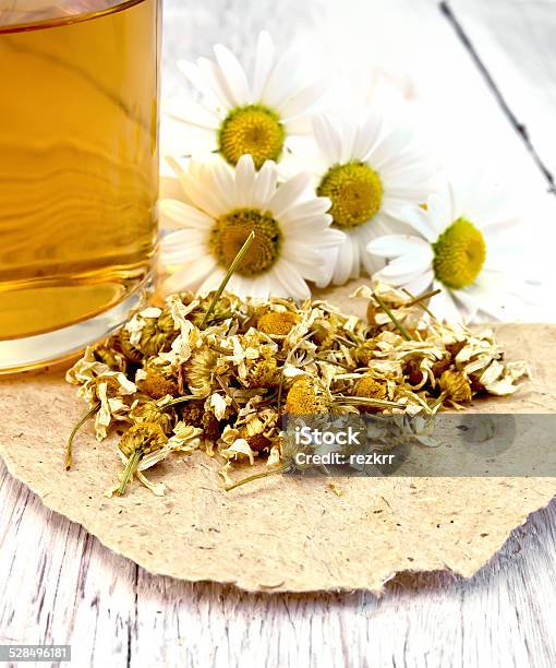 Chamomile Dried On Paper With Glass Mug Stock Photo - Download Image Now - Alternative Therapy, Dieting, Drink