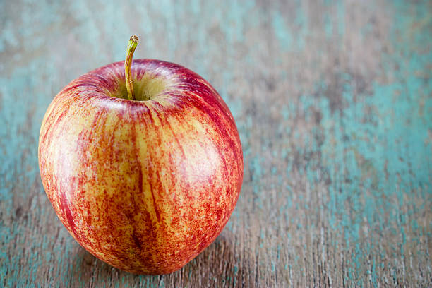 istock Ripe red apple on wooden background 528496291