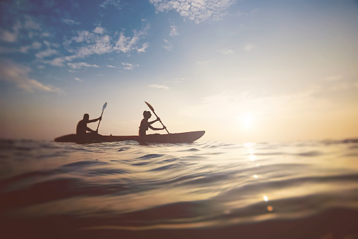 silhouette of a couple on a boat in the sea at sunset