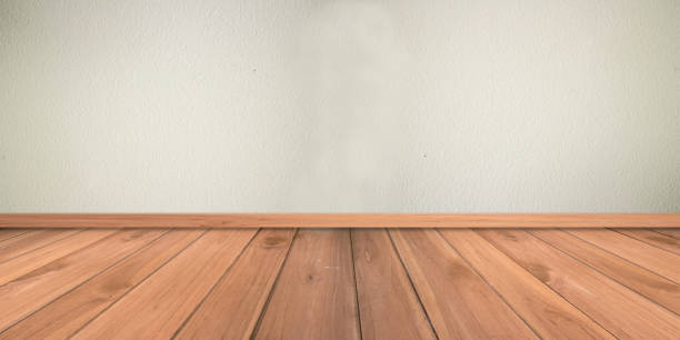 istock white cement plaster wall and wood floor 528496918
