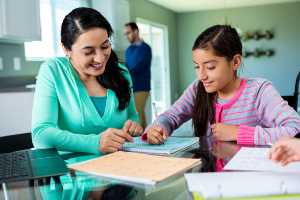 istock Mother tutoring daughter in kitchen 528498492