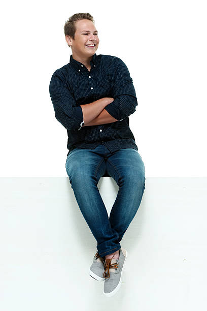 istock Cheerful male sitting on box with arms crossed 528500499
