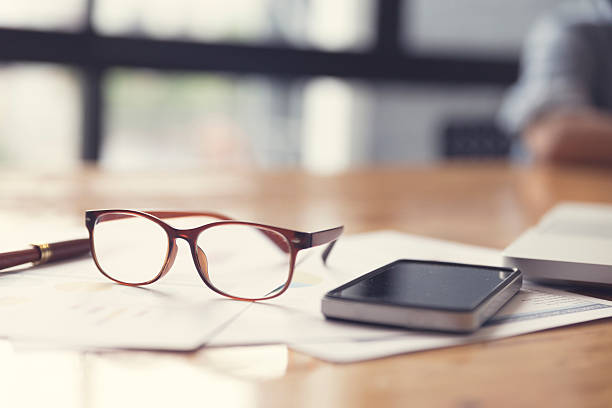 istock eyeglasses, business document and laptop computer notebook on wo 528500650