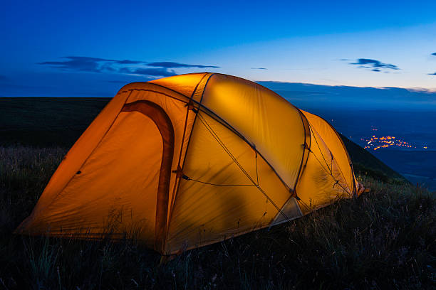 istock Colorful dome tent illuminated at sunset on summer mountain peak 528503324