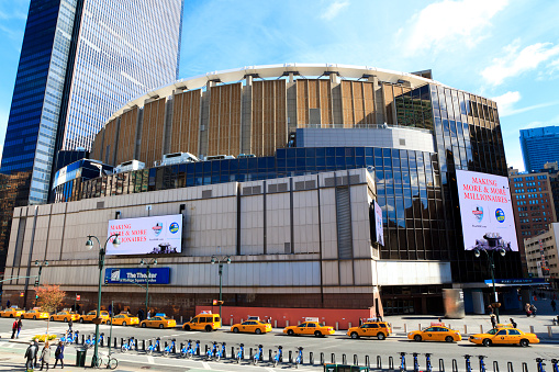 New York City, New York, USA - November 2, 2014: Madison Square Garden: Street view with pedestrians visible outside Madison Square Garden in New York City. This landmark multi-purpose indoor arena, located above Penn Station opened in February 1968.
