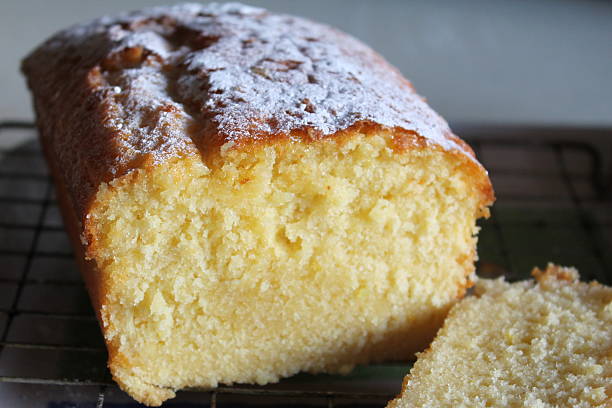 Homemade lemon drizzle loaf cake cooling on rack Homemade lemon drizzle loaf cake. Dusted with icing sugar and cooling on wire rack. Taken with a Canon 1100D SLR camera. pound cake stock pictures, royalty-free photos & images