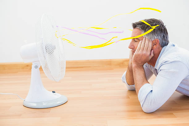 istock Man lying in front of an electronic fan with ribbons 528530075