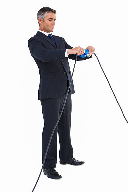 istock Smiling businessman connecting cables together 528530549