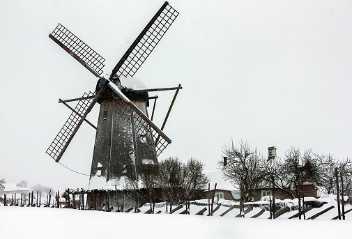 Old traditional windmill in winter landscape