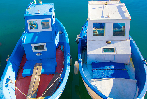 A pair of red, white and blue Mediterranean fishing boats. Shot in Italy.