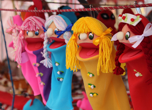 Brightly colored little girl in pigtails puppets.