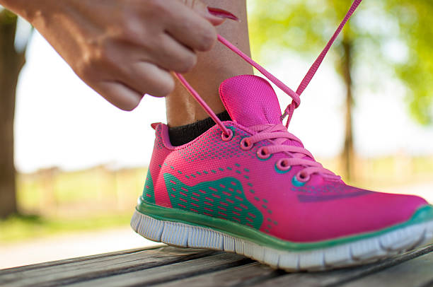 istock Female jogger tying her sports shoe 528552296