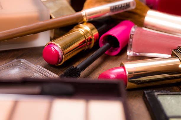 istock Pile of various cosmetics, make-up lie on wooden dressing table. 528552830
