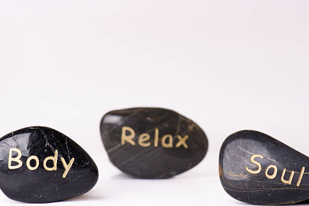 Stone treatment. Black massaging stones isolated on a white background. Hot stones. Balance. Zen like concepts. Basalt stones.