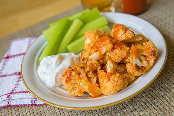 Spicy Buffalo cauliflower bites with dip and celerySpicy Buffalo cauliflower bites with dip and celery