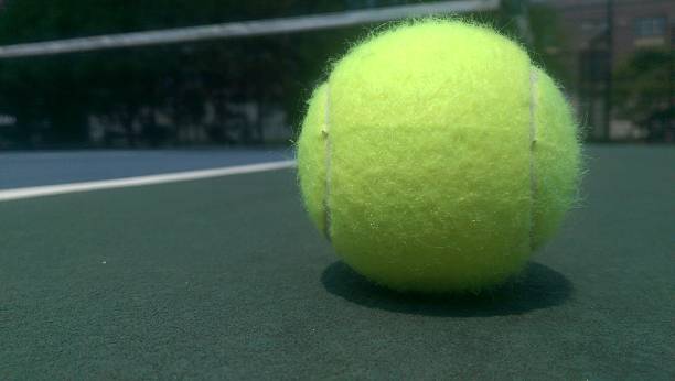 istock Single Tennis Ball on Court 528557846