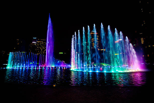istock Illuminated fountain at night in modern city skyline, Kuala Lump 528558408
