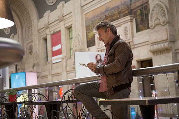 Man uses digital tablet in central train station, Milan