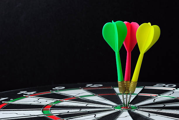 istock Three darts on bulls eye with black background 528560192