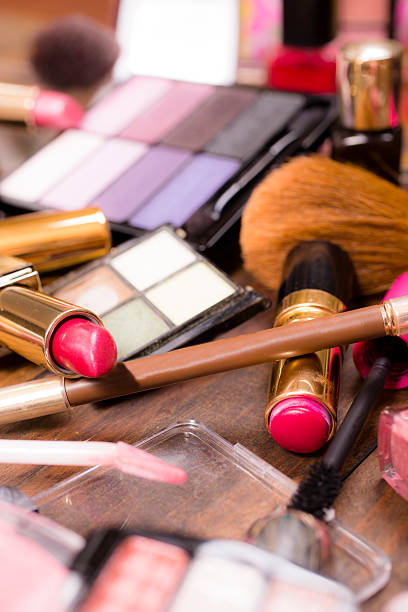 istock Pile of various cosmetics, make-up lie on wooden dressing table. 528560230
