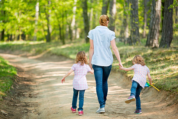 Mother with twin girls walking in forest